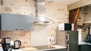 Eine moderne Küche mit Steinwand, Edelstahlgeräten und Holzboden.