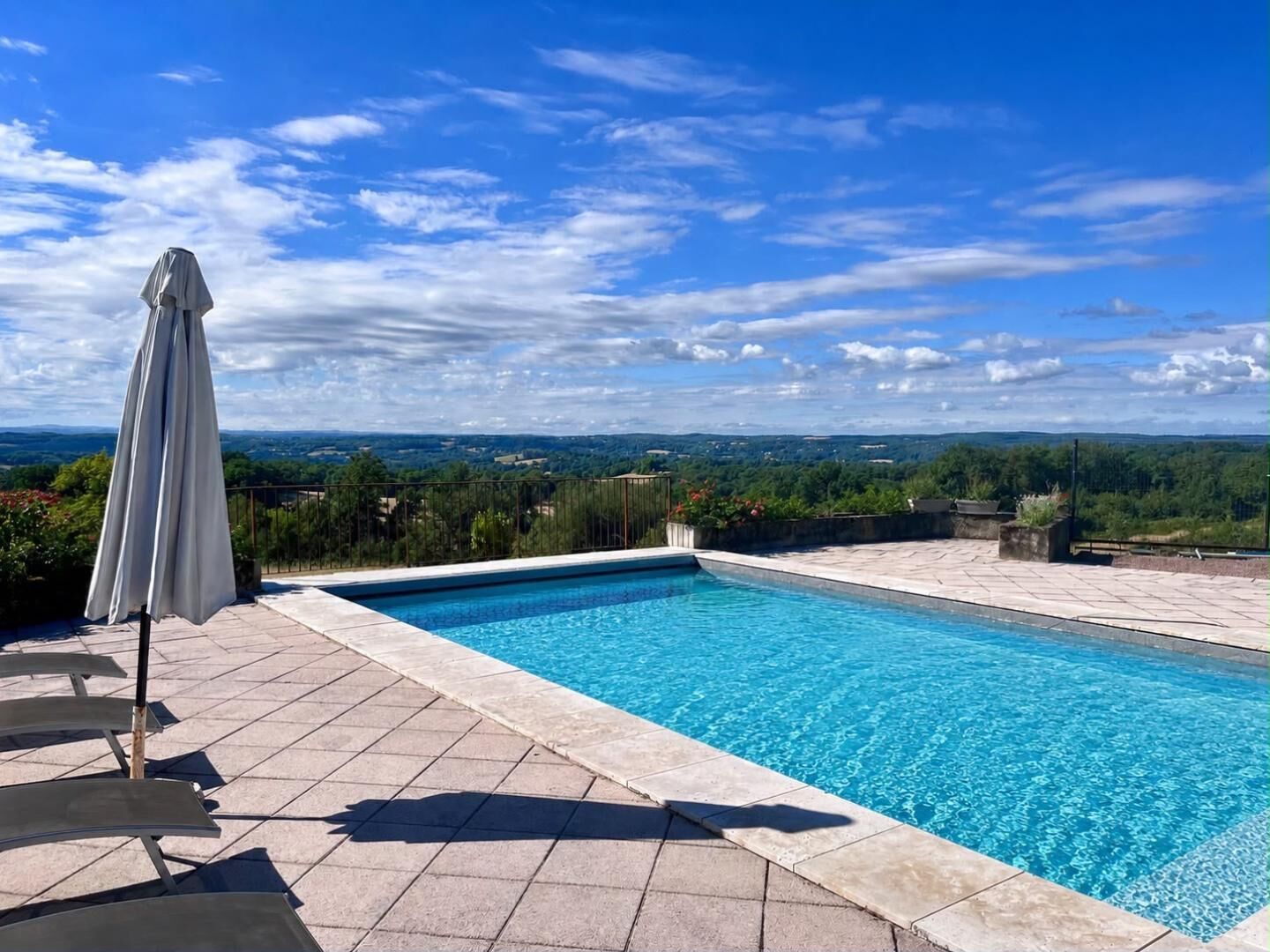 A rectangular swimming pool with a clear blue water surface, surrounded by a tiled deck.