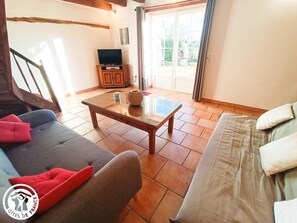 A cozy living room with a sofa, a coffee table, and a television.