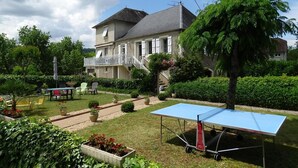 A residential area with a house, outdoor seating, and a ping pong table. - Gîtes de France® - "Chez Destraux" The Restaurant (TAURIAC)