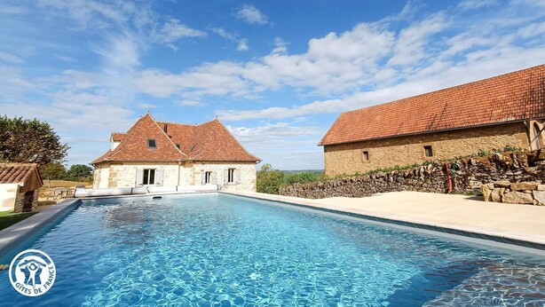 A swimming pool with stone buildings in the background.
