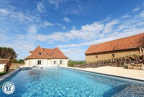 Une piscine avec des bâtiments en pierre en arrière-plan.