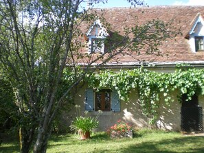 A house with a sloped roof, a small window with shutters, and a door. - 46g1829 - Durbans - Gîte (DURBANS)