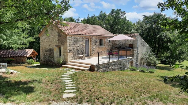 A stone house with a tiled roof, a patio with outdoor furniture, and a stone staircase leading to the entrance. - Gîtes de France® - La Bouyssounade (CRAYSSAC)