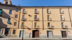 Un edificio de varios pisos con balcones, una farola y cielo despejado.