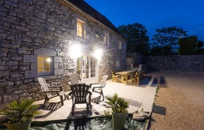 A stone building with a patio area featuring outdoor seating and a small pool. - Gîte Ventoulou - Thegra (THEGRA)
