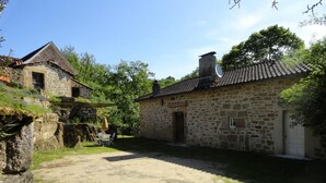A stone building with a tiled roof, a door, and a small window. - Gîtes de France® - Les gites de La Grave 1 (CARDAILLAC)