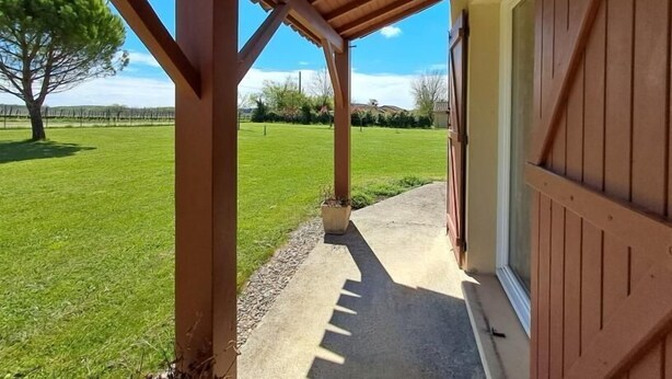 A covered outdoor area with a concrete path leading to a building. - Gîtes de France® - Le TRUFFADOU (SAUZET)