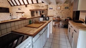 Una cocina con estufa, lavaplatos y encimera de madera.