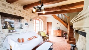 Une chambre à coucher rustique avec un grand lit, une chaise en bois, une petite table et un escalier.