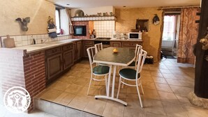 Une cuisine avec un îlot central, des chaises blanches et une table à manger.