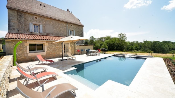 A stone house with a swimming pool, outdoor seating, and a garden. - Gîtes de France® - Gîte des Escures (SAINT CHELS)
