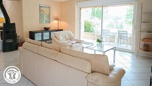 Una sala de estar con sofá, una mesa, una lámpara y una chimenea.