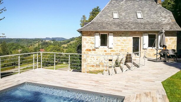 A stone house with a swimming pool, outdoor seating, and a view of the countryside. - Gîtes de France® - La Belle Lotoise (TEYSSIEU)