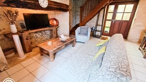 Ein rustikaler Wohnraum mit einem Holztv-Schrank, einem Sofa, einem Couchtisch und einem Sessel.