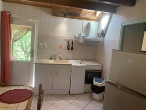 A compact kitchen with a sink, stove, and a refrigerator.