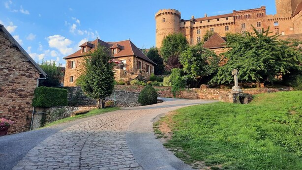 Un castello con un sentiero in pietra che conduce a un edificio in pietra con un tetto rosso.