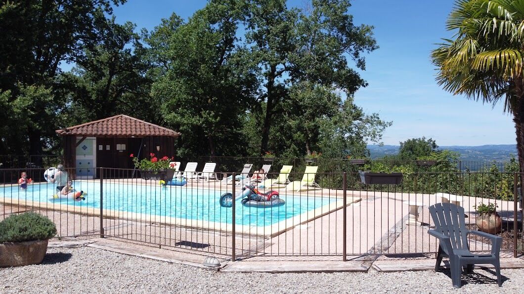 Una piscina con sillas de descanso, una pequeña cabaña y vistas del paisaje.