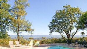A swimming pool with lounge chairs and a view of the landscape.