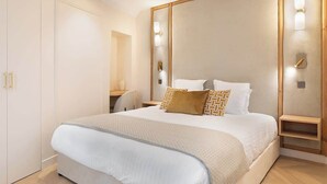 A modern bedroom with a large bed, a wardrobe, and a desk.