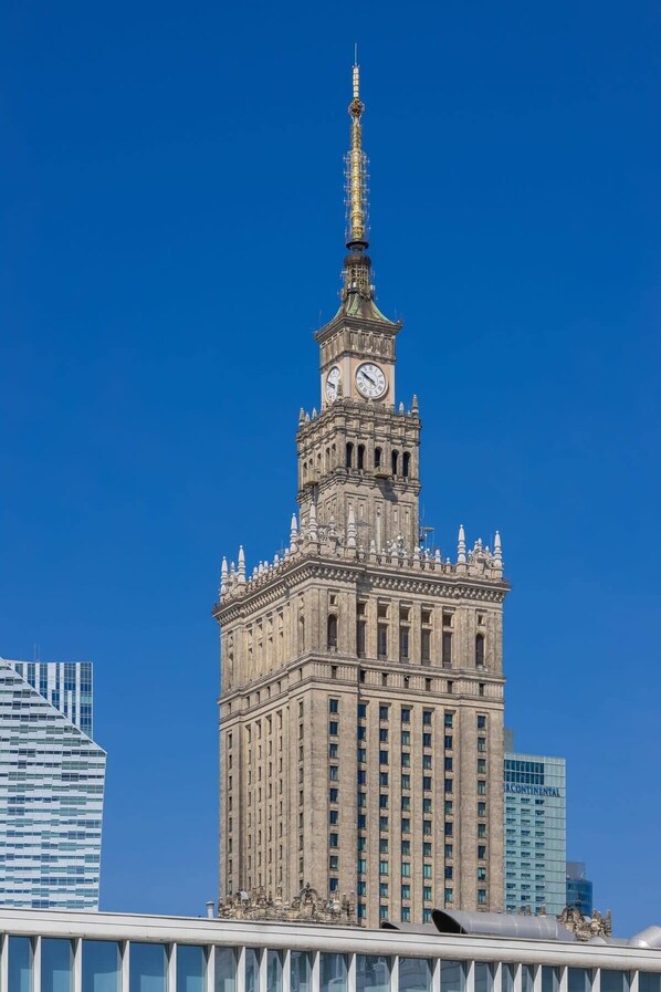 Ein historisches Gebäude mit einem Glockenturm, das einen klassischen Baustil mit aufwendiger Steinmetarbeit und einem markanten Turmaufbau zeigt.