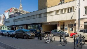 A building with a KFC restaurant, parked cars, and bicycles.