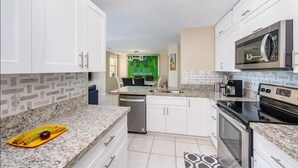 A modern kitchen with white cabinets, granite countertops, a microwave, stove, and a dishwasher. - Best view in Aventura Yacht Club, 2-bedroom condo fully equipped  (Aventura)