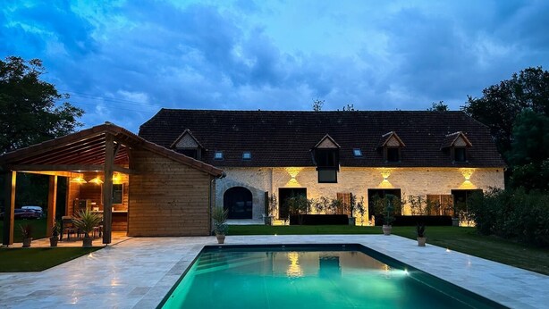 Un bâtiment à deux étages avec une piscine devant.