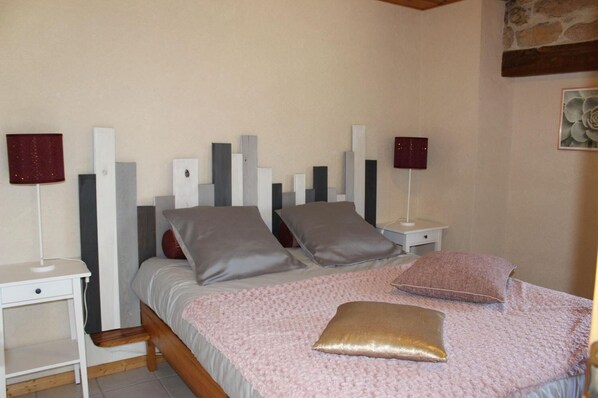 Un dormitorio con una cama, dos mesitas de noche y una mesilla.