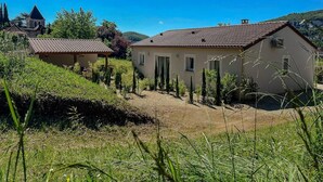 Un ambiente rurale con una casa dotata di tetto in tegole e un piccolo giardino.