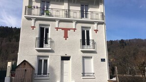 Ein zweistöckiges Gebäude mit Balkon, Tür und Fenstern.