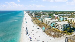 Un hôtel situé sur la côte, avec accès à la plage, une piscine et plusieurs bâtiments.
