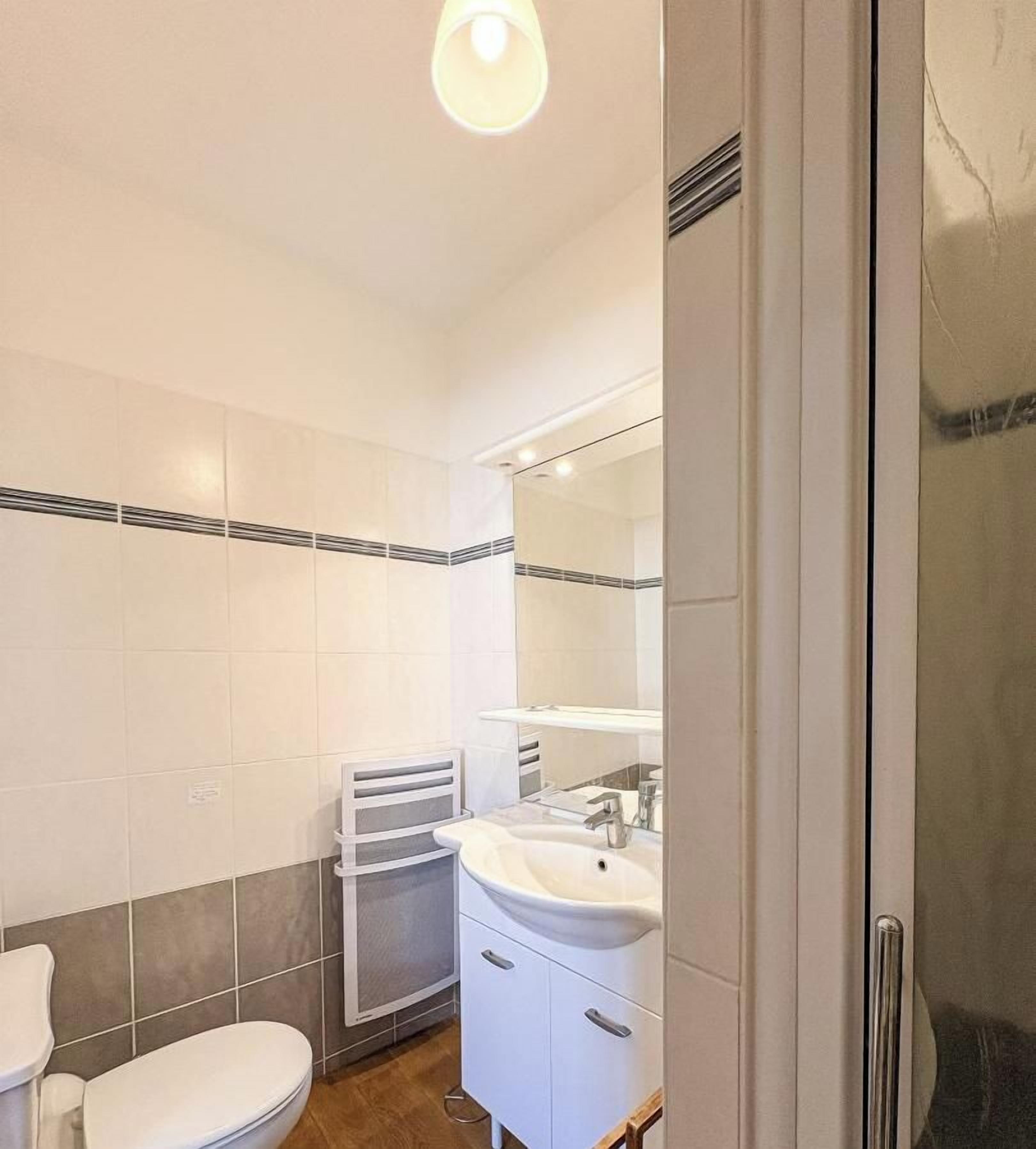 Un baño con inodoro, lavamanos y espejo.