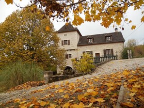 A stone building with a traditional design, featuring a prominent chimney and a small window.