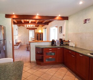 A kitchen with a built-in refrigerator, wooden cabinets, and a countertop with various appliances.
