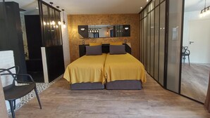 Un dormitorio moderno con una cama grande, una silla y un espejo.