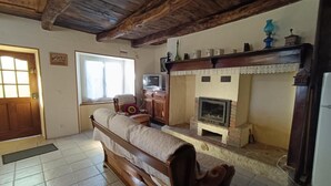 Una habitación acogedora con un banco de madera, una chimenea y un televisor.
