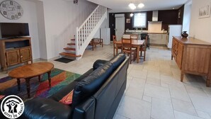 A modern apartment with a living room, dining area, kitchen, and staircase. - Chez Yvette - Saint-sozy (SAINT-SOZY)
