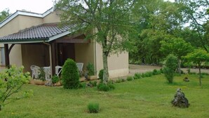 A house with a covered porch, a small lawn, and a few potted plants. - Gîtes de France® - 46G1905 (SAINT GERY-VERS)