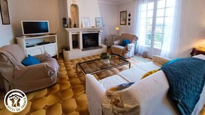 A living room with a fireplace, a television, and comfortable seating.