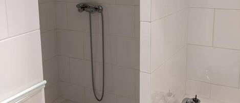 A bathroom with a shower, a bathtub, and a toilet.