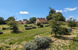 A rural landscape with houses, trees, and a clear sky.
