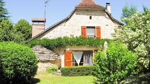 A stone house with a sloped roof, wooden shutters, and a chimney. - Gîtes de France® - Le Poutoy (SAINT-SIMON)