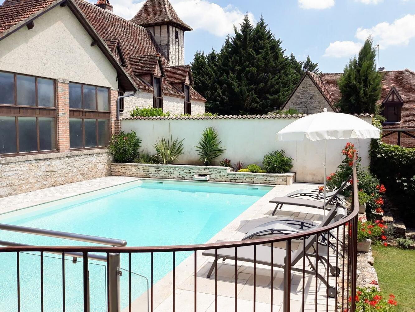 A swimming pool with a stone wall and a wooden deck.
