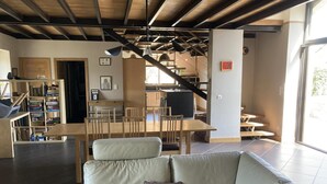 Un espacio habitable moderno con sofá, mesa de comedor y área de cocina.