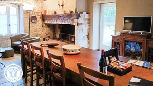 Un comedor rústico con una mesa de madera, sillas y una chimenea.
