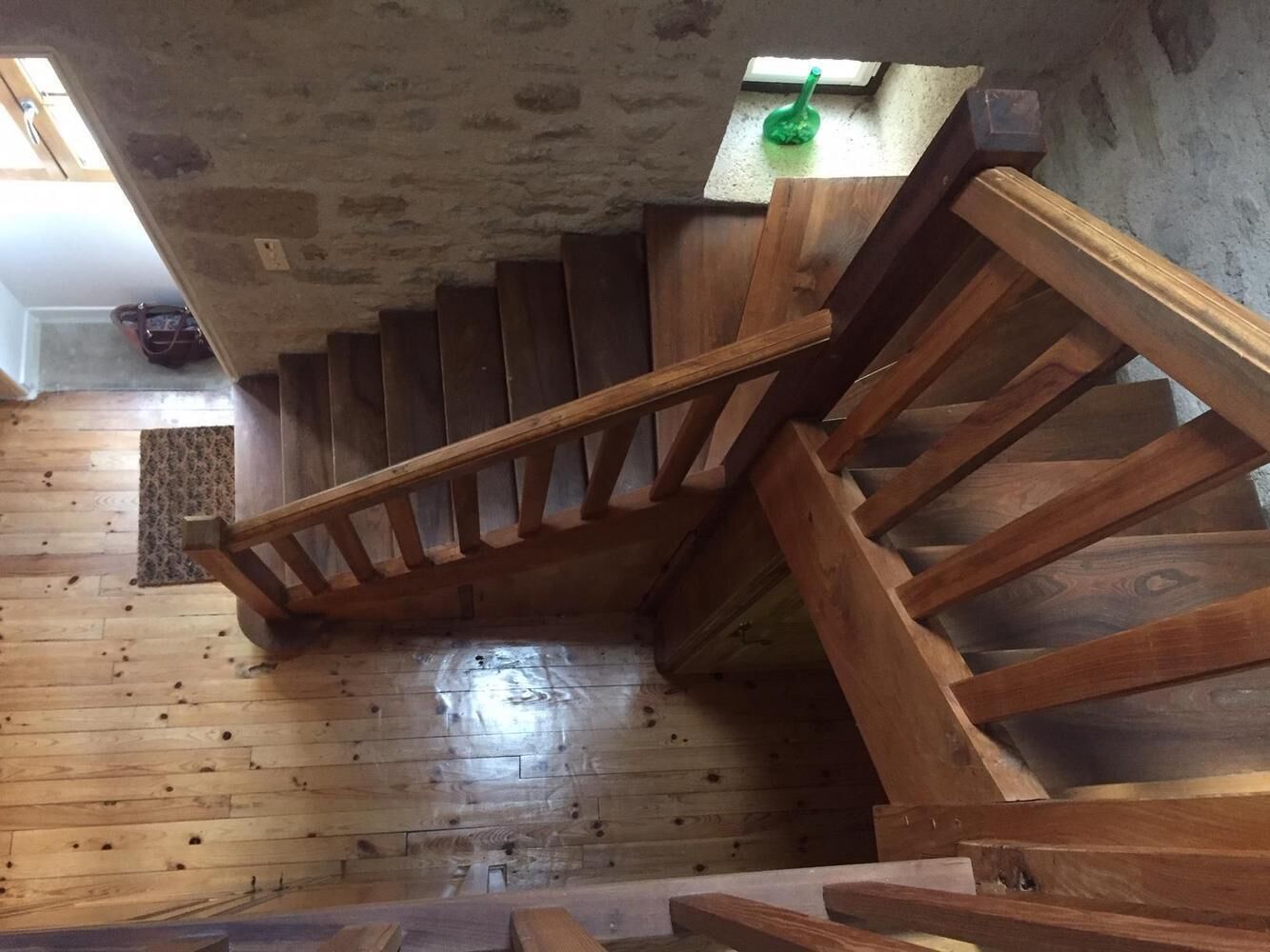 A wooden staircase in a room with a concrete ceiling and a wooden floor.