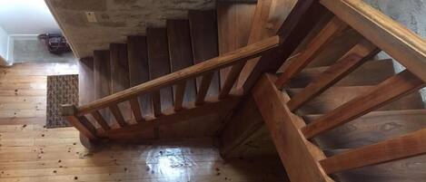 A wooden staircase in a room with a concrete ceiling and a wooden floor.