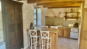 Una cucina con tavolo e sedie in legno, un forno a microonde e un frigorifero.