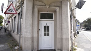 A building entrance with a white door marked with the number 2, a pedestrian crossing sign, and a no parking sign. - Fewo Wuppertal (Wuppertal)